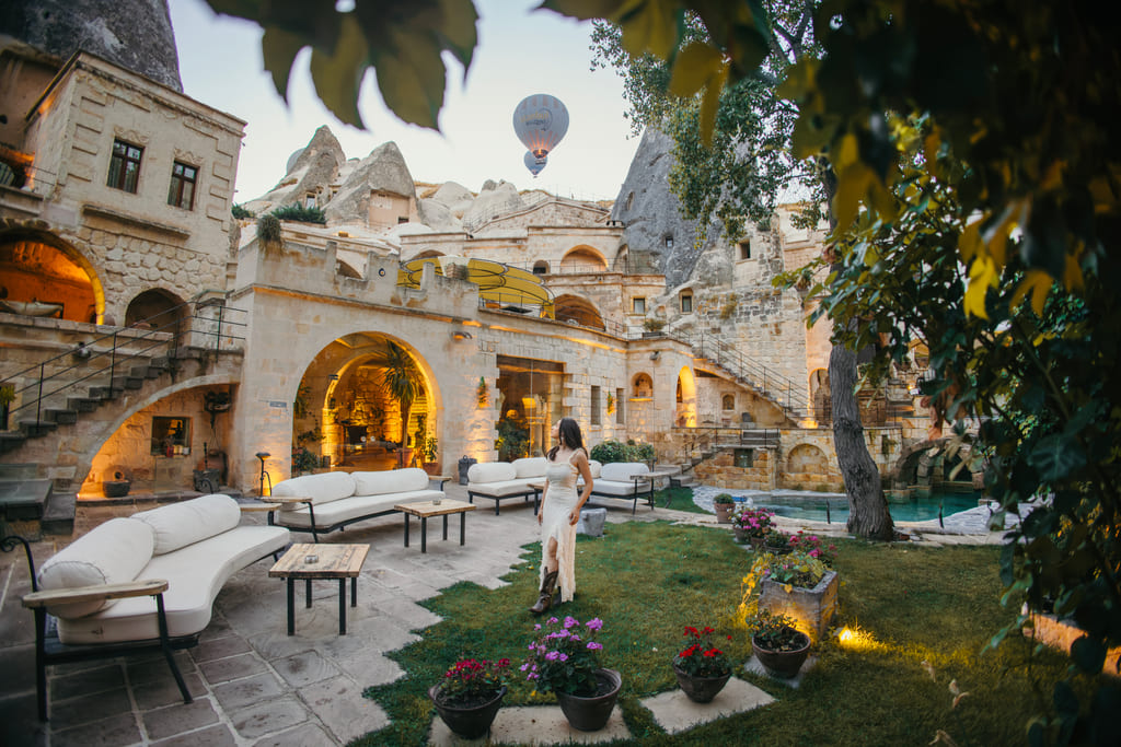 Anatolian Houses avlusunda bir misafir, peribacalarının üzerinde balonlar